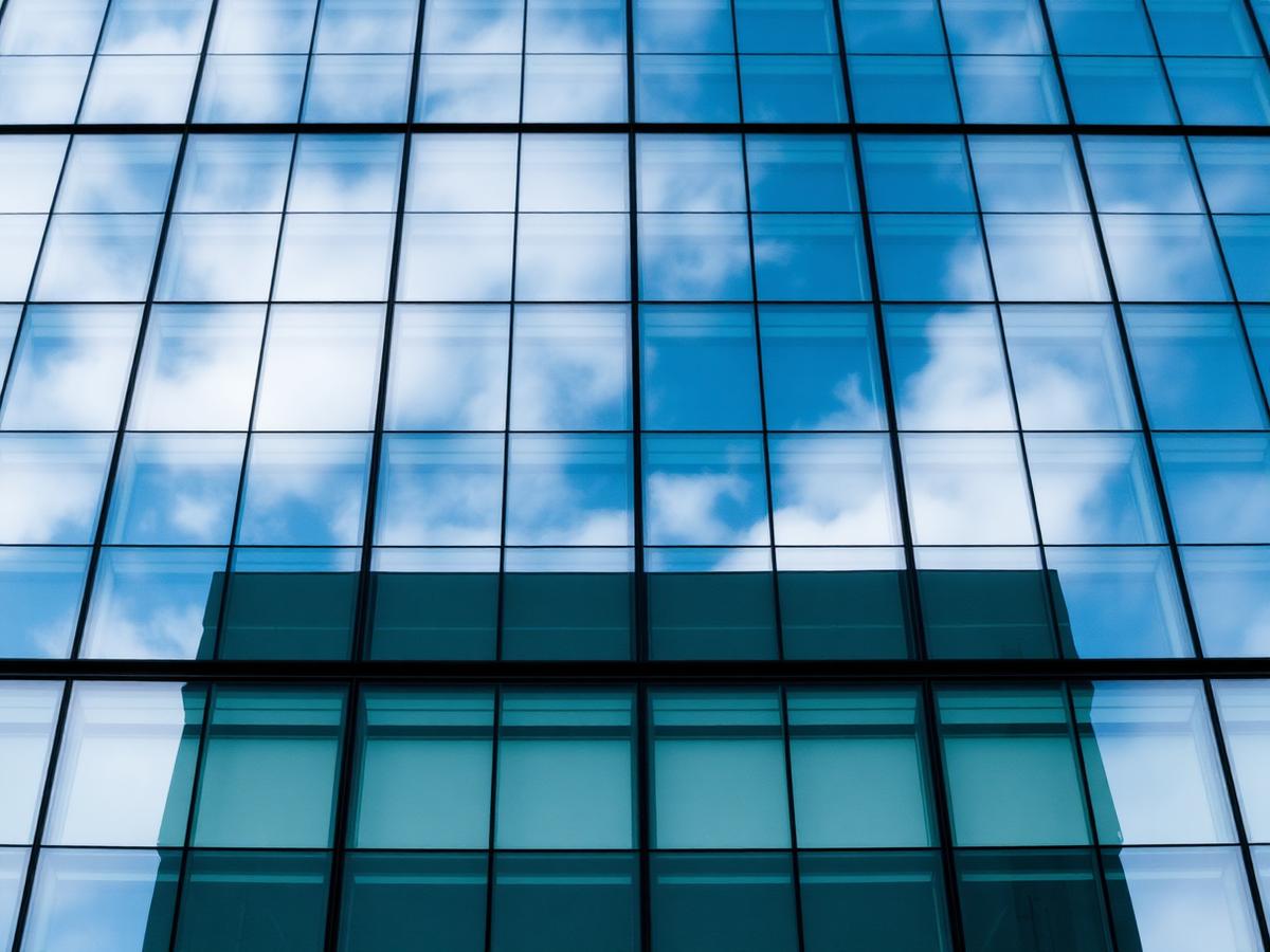 Fachada de vidro refletivo espelhando o céu